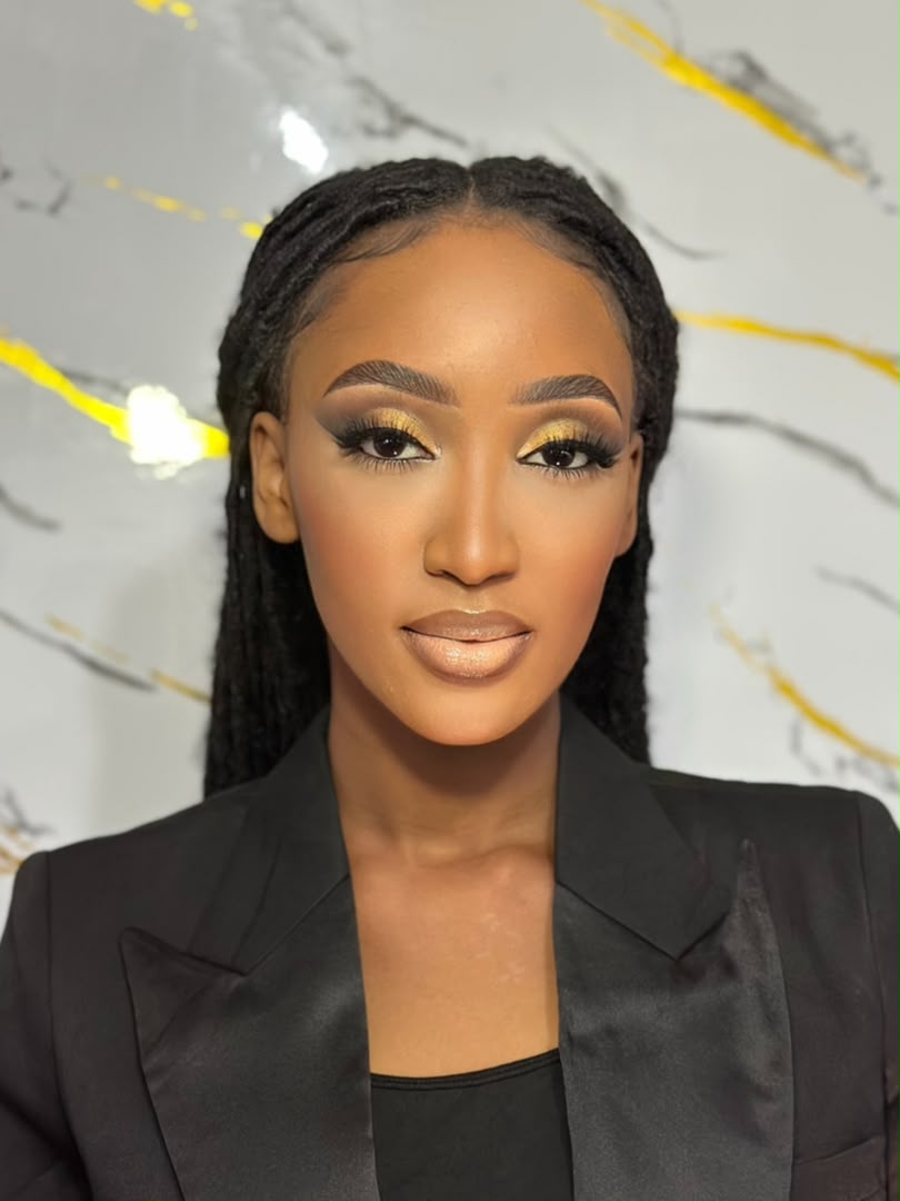 Maquillage de soirée aux paupières dorées et regard souligné, coiffure en locs